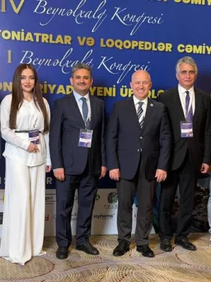 Op. Dr. Dilşad Şadlinskaya «Foniatriyada yeni üfüqlər» konqresində, konqres bannerinin önündə digər iştirakçılarla